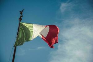 Italia bandera ondulación en el viento en el azul cielo antecedentes. foto