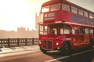 Classic English Red Bus on the Westminster Bridge and Big Ben Tower in the background. photo