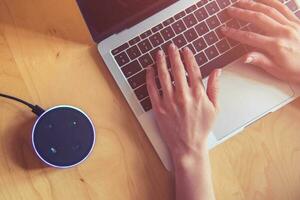 Women working on her computer with voice assistant photo