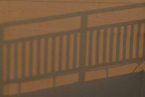 In the morning light, the shadow of the railing on the wall photo