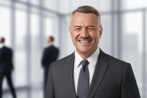 Smiling businessman, standing in blur background of office. photo