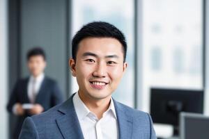 Young smart businessman, standing in blur background of office. photo