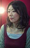 retrato foto de hermosa medio Envejecido asiático mujer en oscuro habitación con ligero en fondo, generativo ai