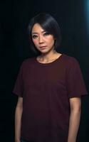 portrait photo of beautiful middle aged asian woman in dark room with light in background, generative AI