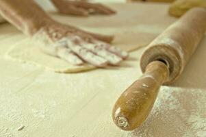 Handmade Food - Hand on Dough and a Rolling Pin photo