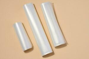 Rolls with polyethylene film for vacuum packaging of products on a beige background, top view photo