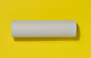 White paper towel from a roll of kitchen towels, object on a yellow background, top view photo