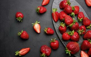 Ripe red strawberries on a black table photo