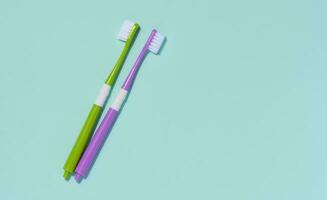 dos el plastico cepillos de dientes en un azul fondo, oral higiene. foto