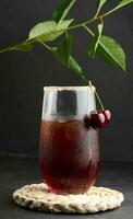 Cherry juice in a glass on a black background photo