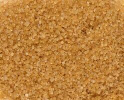 Texture of granulated brown cane sugar, top view photo