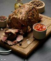 Baked pork collar with spices on a wooden board, delicious and juicy meat photo