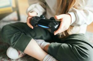 pequeño niña jugando en juegos consola foto