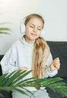 Cute little girl listening to music in headphones photo