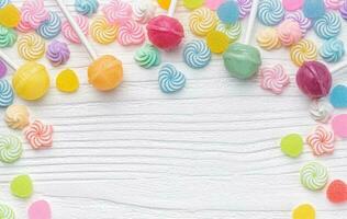Sweet lollipops and candies on white wooden background photo