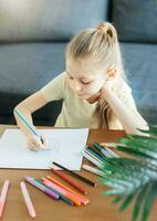 Child girl drawing with colorful pencils photo