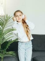 Cute little girl listening to music in headphones photo