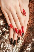 Hands of a young girl with red  and black manicure on nails photo