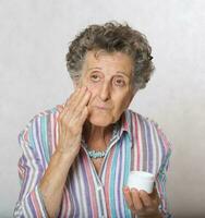 Senior woman with a box of face cream photo