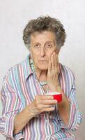 Senior woman with a box of face cream photo