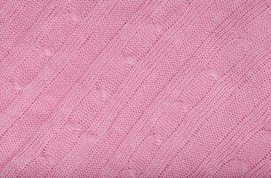Pink coloured knitted surface. Closeup photo