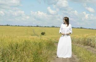 joven dama vestido en blanco corsé en el campo foto