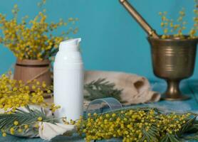 Mimosa cream dispenser on a wooden surface. Closeup photo