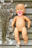 Abandoned plastic doll on wooden surface photo