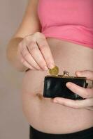 joven embarazada mujer mantiene pequeño cuero cartera. foto