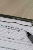 Mental health intake form and a pen on a table. photo