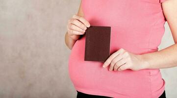 Young pregnant woman keeps her travel pass. Closeup photo