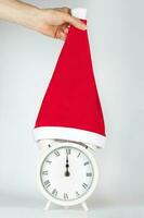 Vintage alarm clock in Santa Claus hat. photo