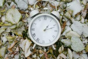 Vintage clock on dry leaves photo