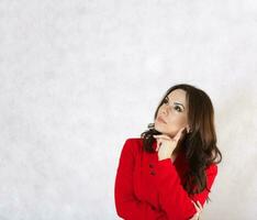 A young thoughtful  woman in a red classical jacket. photo