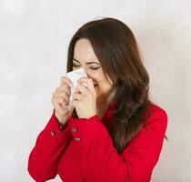 A sneezing young woman dressed in a classical costume. photo