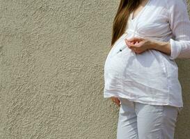 The pregnant woman keeps a syringe photo