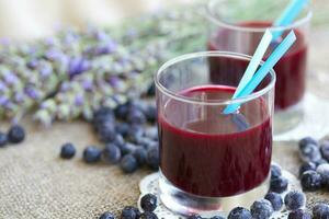Glass of blueberries juice on a sackcloth. Closeup photo