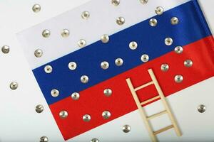 Pins,service pass of an European official and mini wooden made ladder on a Russian flag. Background photo