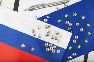 Pins on two flags of EU and Russia. Closeup photo