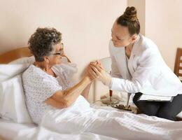 Visit of senior social work assistant to an old woman photo