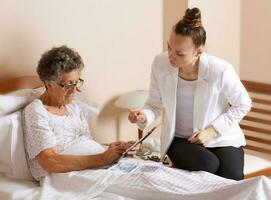 Visit of senior social work assistant to an old woman photo