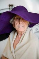 Old caucasian woman in a violet hat photo