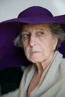 Old caucasian woman in a violet hat photo