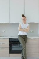 Young lady stays in front newly installed kitchen photo
