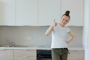 joven dama corsé en frente recién instalado cocina foto