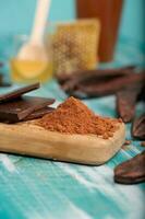 Carob pods and powder on a wooden surface. photo