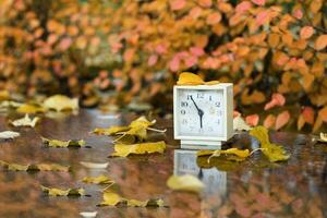 Old square alarm clock on a marble stone covered by rain. photo