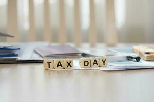 Word Tax Day composed of wooden letters. Closeup photo