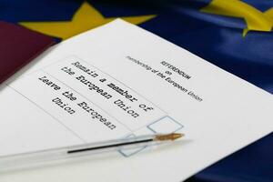 EU Referendum ballot paper, black pen, and passport on the table. photo