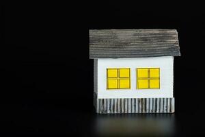 Small paper house on a black surface. photo